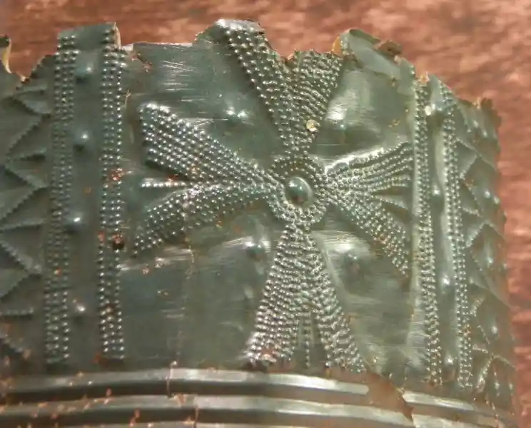 Four-point cross on a bronze ornament